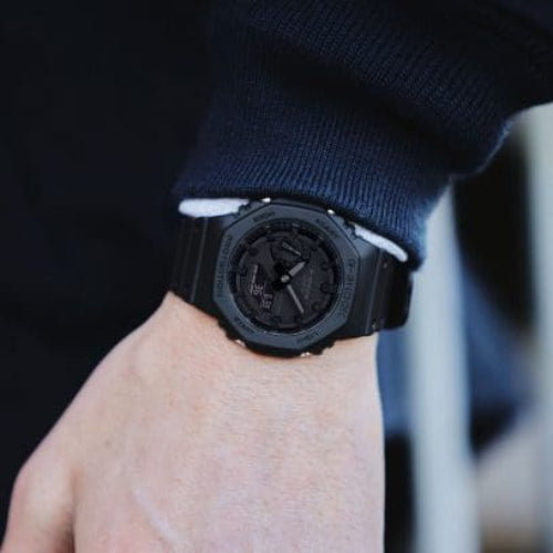 Black watch on a wrist with a blurred background